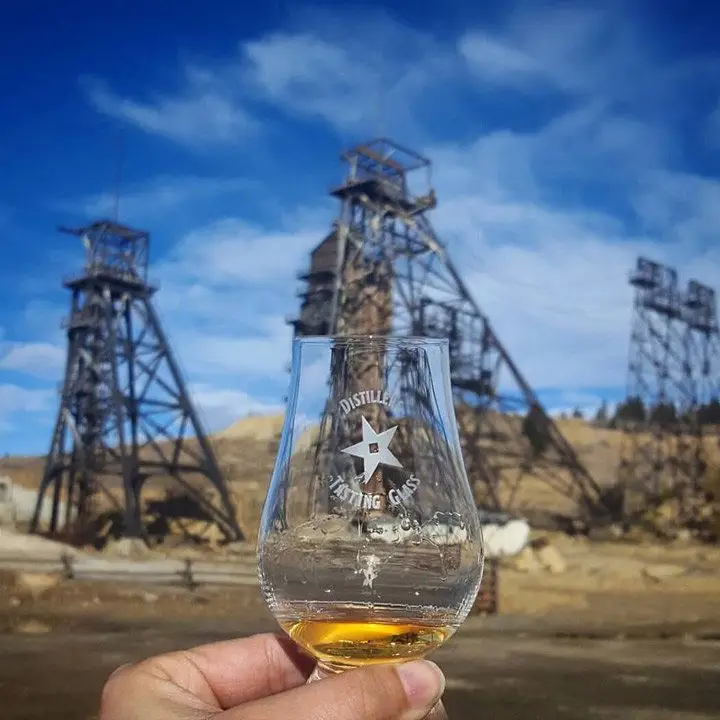Headframe Spirits, Montana with oil rigs in the background