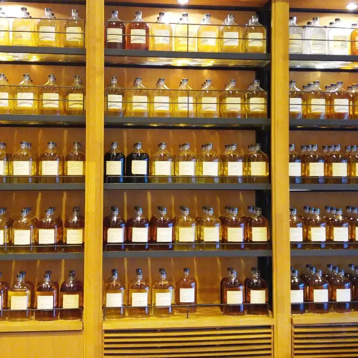 Yamazaki Distillery tasting room. Bottles are right next to each other, packing the shelves of the room