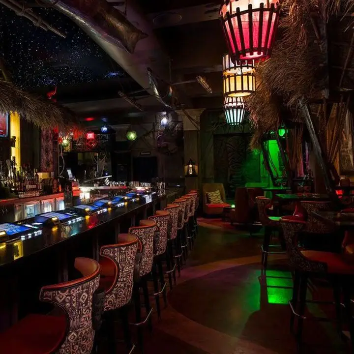 The Golden Tiki bar. Gambling mechanisms are inlaid in the bar and a green light hovers in teh background