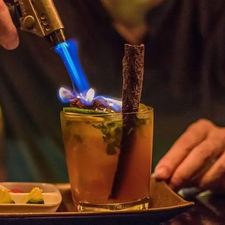 A cocktail at the Unicorn Pub, wiht the garnish being set on fire with a mini blowtorch