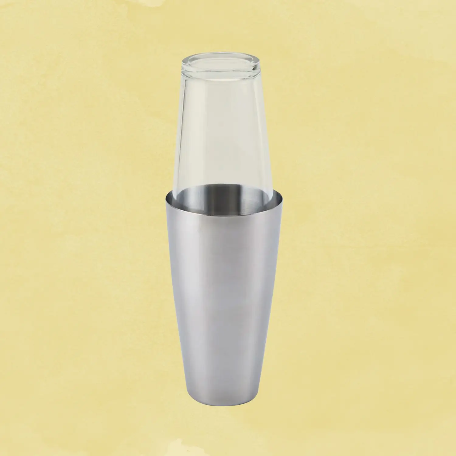 Glass on tin Boston shaker against a yellow background