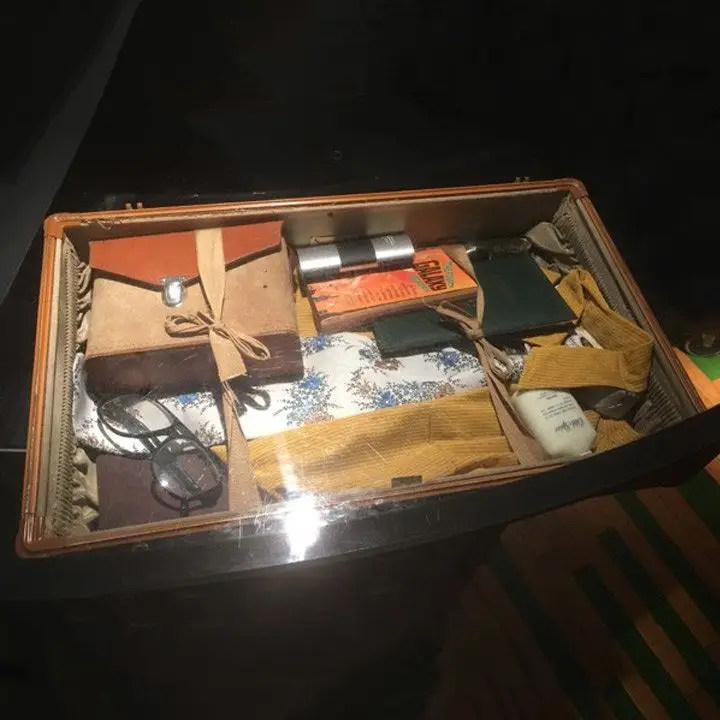 Root Down bar top with a piece of vintage luggage and its contents on full view