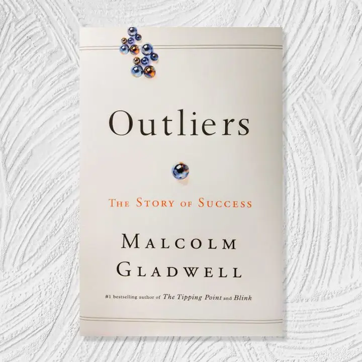 Outliers cover, off white with black and orange text and a cluster of shiny blue and orange beads at the top left and a larger blue and orange bead in the center