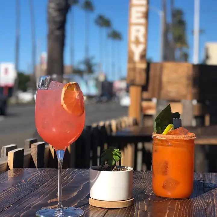 Farmhouse at Pacific Coast Spirits in San Diego. An outdoor table with two refreshing cocktails
