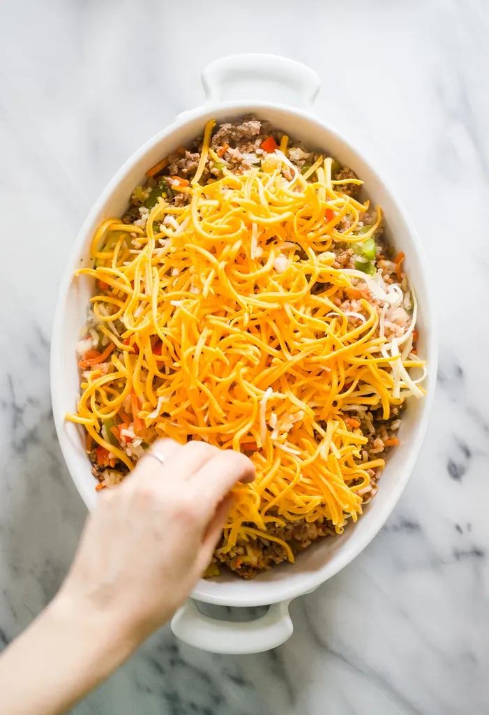 Sprinkling the cheese on top.' title='Easy Stuffed Pepper Casserole