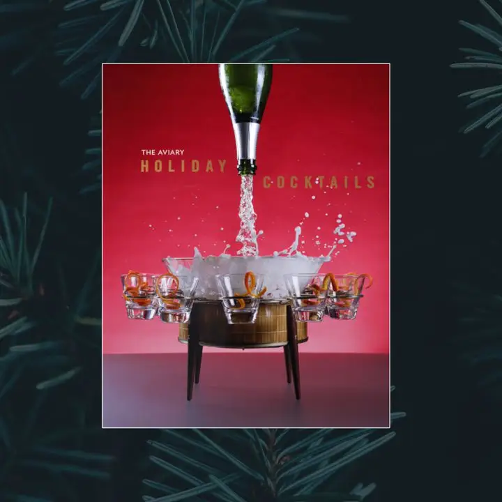 The Aviary: Holiday Cocktails cover featuring a red-to-white gradient background and a bottle of sparkling wine being poured from the top of the cover into a barrel-esque punch bowl with five orange zest-garnished glasses attached
