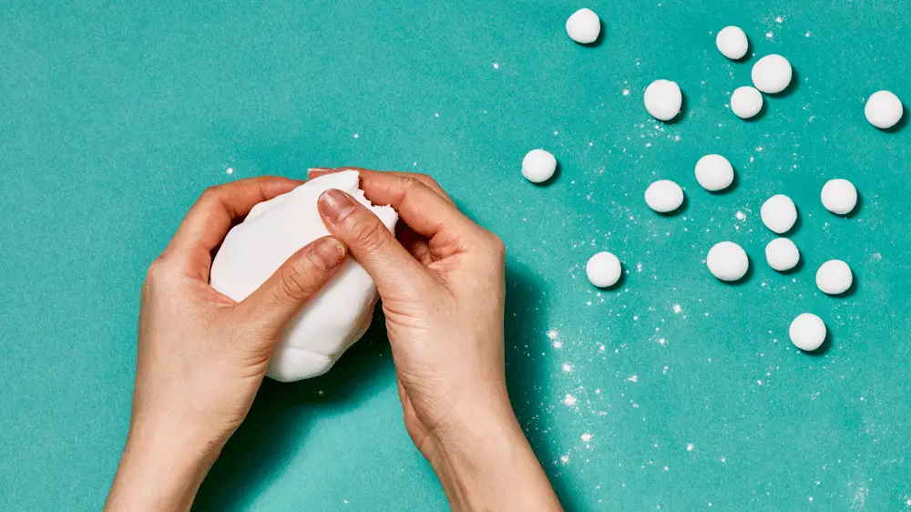 A GIF of hands pulling dough apart and rolling the pieces into balls.