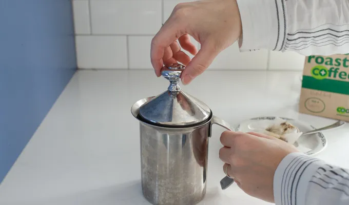 Frothing the milk with the hand pump milk frother.' title='Dirty Chai Latte