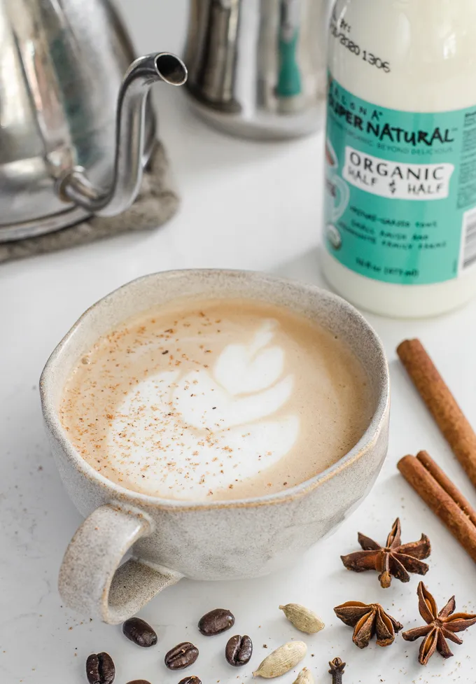A mug of dirty chai latte with spices around it.' title='Dirty Chai Latte