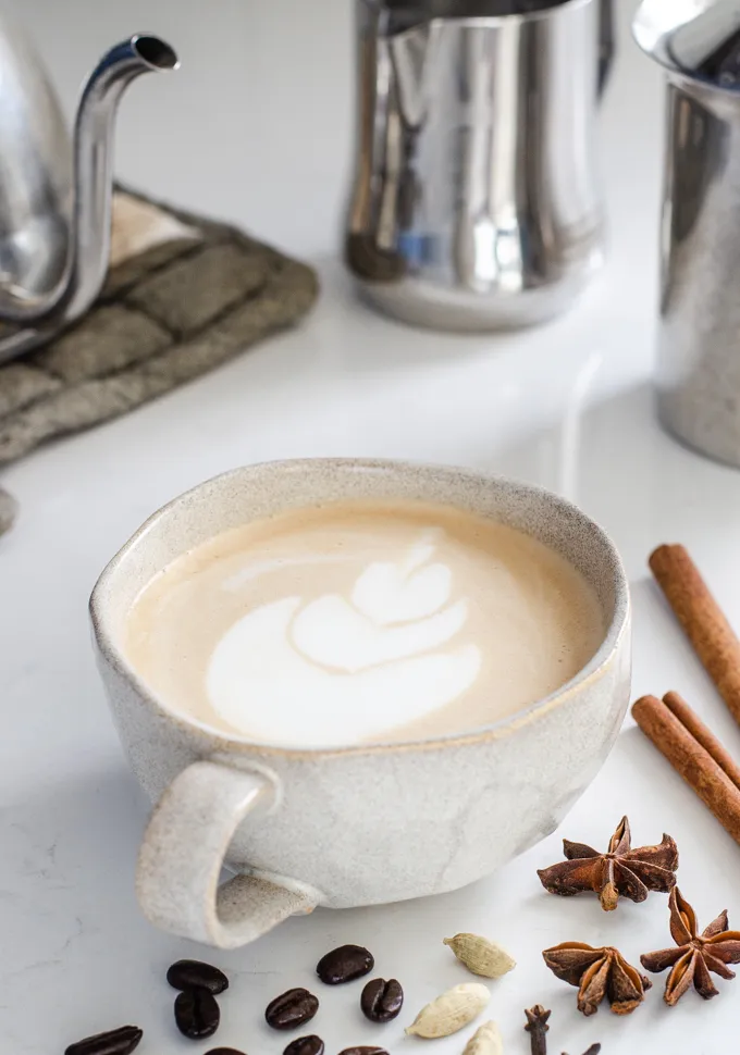 A mug of dirty chai latte with spices around it.' title='Dirty Chai Latte