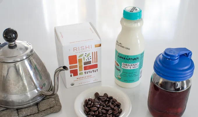 All of the ingredients to make a dirty chai latte laid out on a white countertop.' title='Dirty Chai Latte