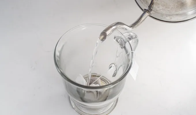 Pouring boiling water on top of the chai tea bag in the mug.' title='Dirty Chai Latte