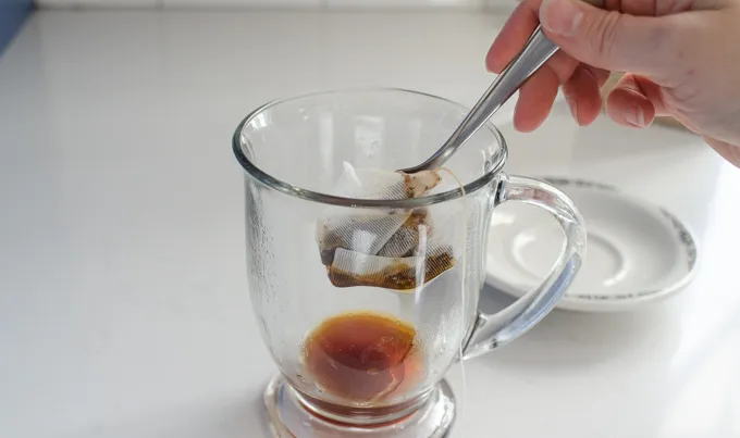 Squeezing out the chai tea bag into the mug.' title='Dirty Chai Latte