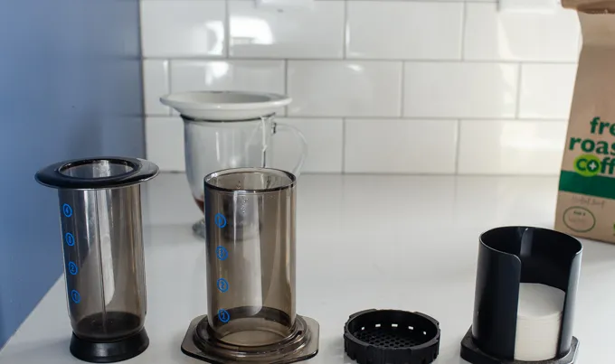 The parts of an aeropress coffee maker on a counter.' title='Dirty Chai Latte