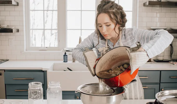 Straining the chicken feet stock through a fine mesh sieve.' title='Chicken Feet Bone Broth Recipe