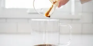 Pouring a shot of espresso into a clear glass mug.' title='Peppermint Mocha Starbucks Recipe