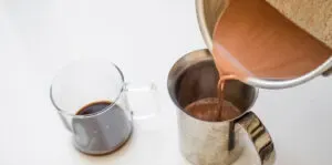 Pouring the chocolate and milk mixture into a hand pump milk frother.' title='Peppermint Mocha Starbucks Recipe