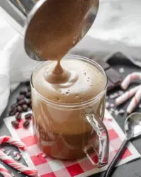 Pouring the frothed milk and chocolate over the espresso in the mug.' title='Peppermint Mocha Starbucks Recipe