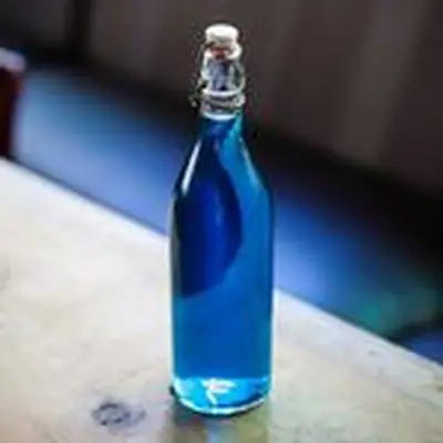Homemade blue curaçao in a swing-top bottle