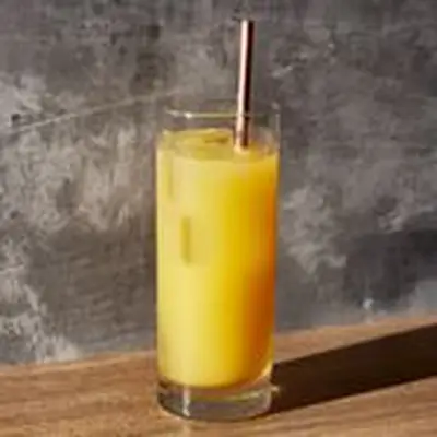 Orange Screwdriver cocktail in a highball glass with metal straw, on slate gray background