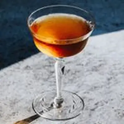 amber-colored Cooperstown cocktail in a cocktail glass, served on a gray granite surface