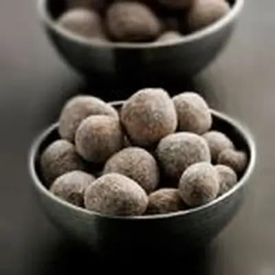 two gray bowls filled with Bourbon Balls served on a gray surface