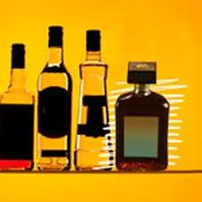 Photo illustration of four various liquor bottles with their labels blacked out, one of which is emphasized with white hand-drawn lines on the far right of the lineup.