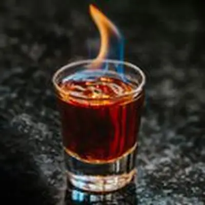 Flaming Dr. Pepper Shot served in a shot glass with a blue-and-orange flame