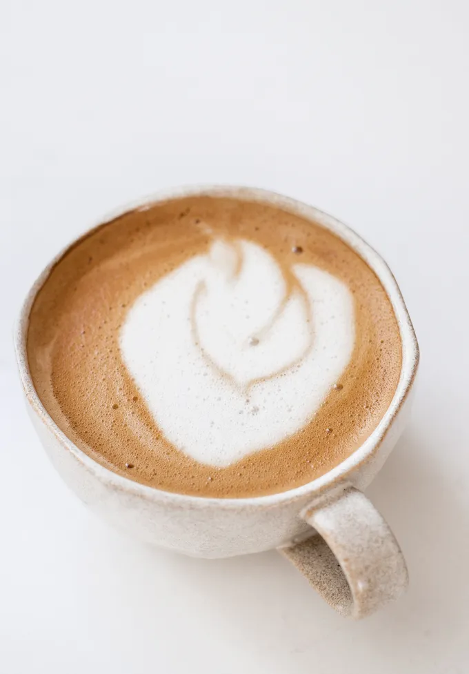 An oat milk latte in a stoneware mug.' title='Oat Milk Latte