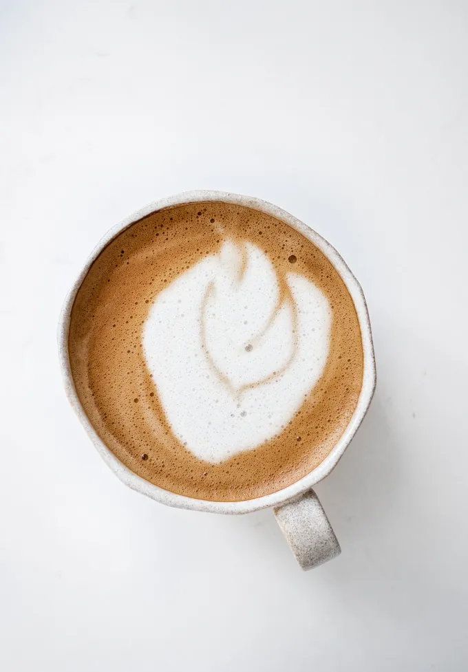 An oat milk latte in a stoneware mug.' title='Oat Milk Latte