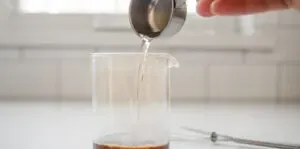 Pouring hot water over instant coffee in a mini glass pitcher.' title='How to Make an Espresso Shot with Instant Coffee