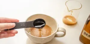 Adding vanilla syrup to instant coffee espresso in a 12 ounce stoneware mug.' title='How to Make an Espresso Shot with Instant Coffee