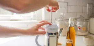 Frothing milk with a French press to pour over instant coffee espresso.' title='How to Make an Espresso Shot with Instant Coffee