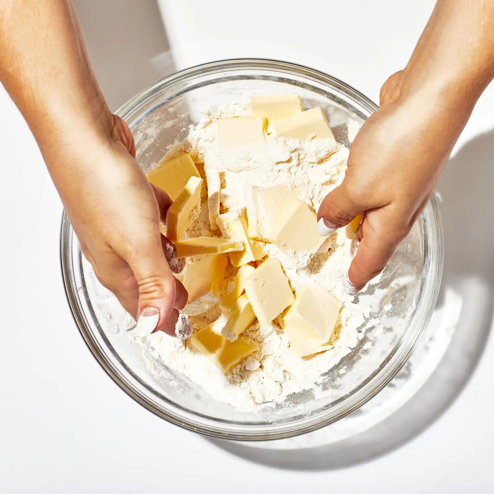 Hands in bowl of flour and butter.