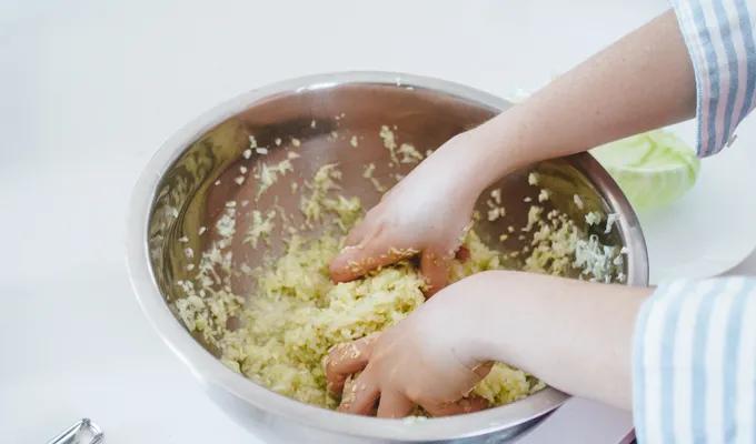 Massaging cabbage for homamde sauerkraut.' title='Easy Spicy Sauerkraut Recipe