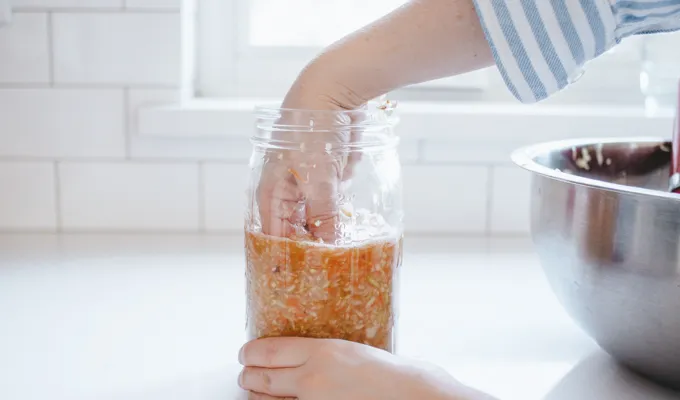 Packing the kraut into the sterile mason jar.' title='Easy Spicy Sauerkraut Recipe