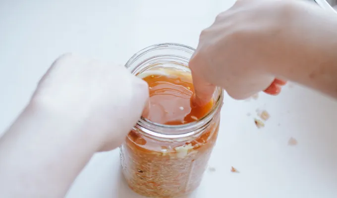Putting the leaf on top of the kraut in the jar.' title='Easy Spicy Sauerkraut Recipe