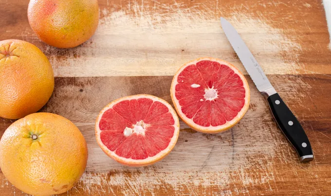 How to eat a grapefruit with a spoon: start by slicing it in half.' title='How to Cut a Grapefruit