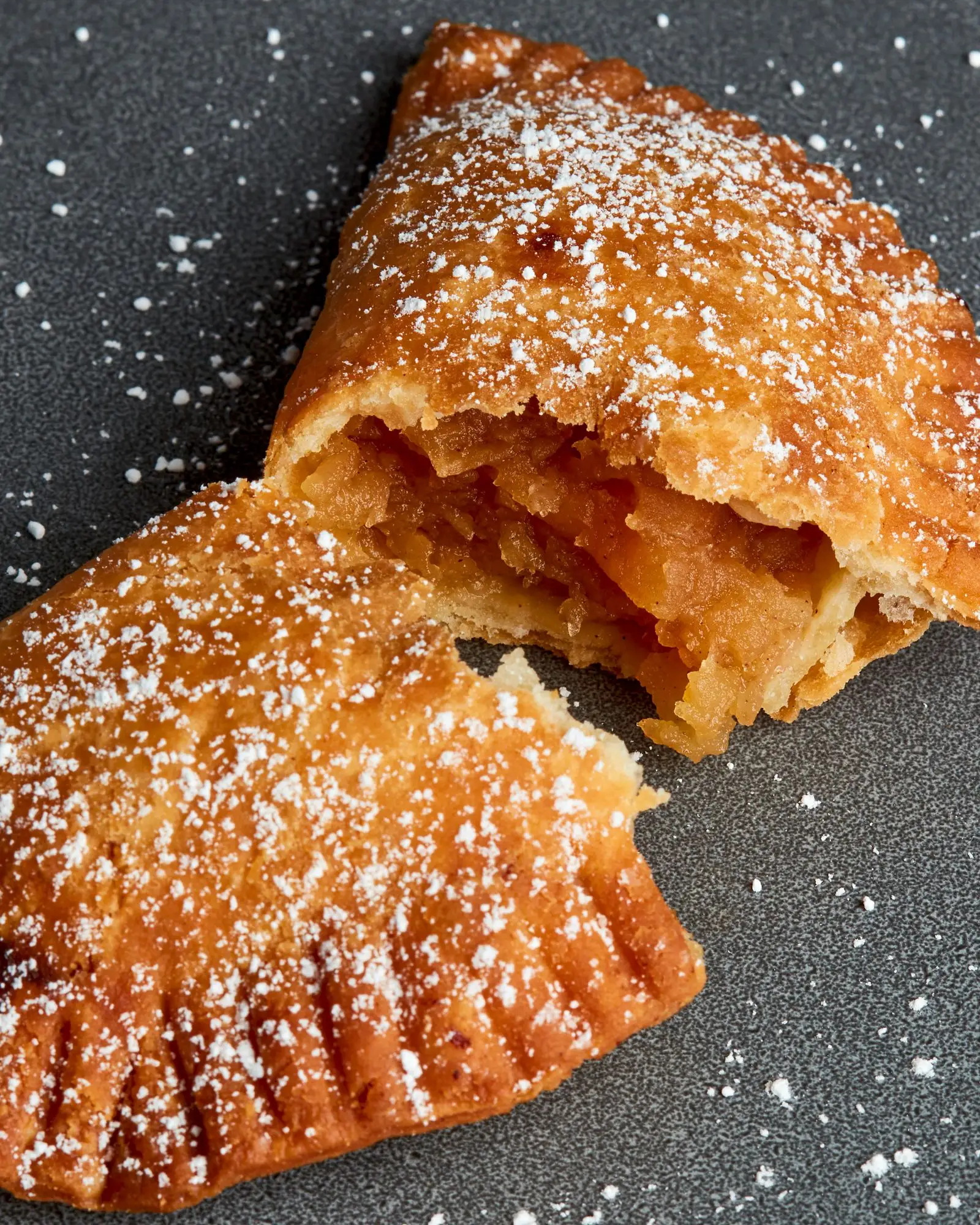Fried dough filled with pured apples topped with confectioner