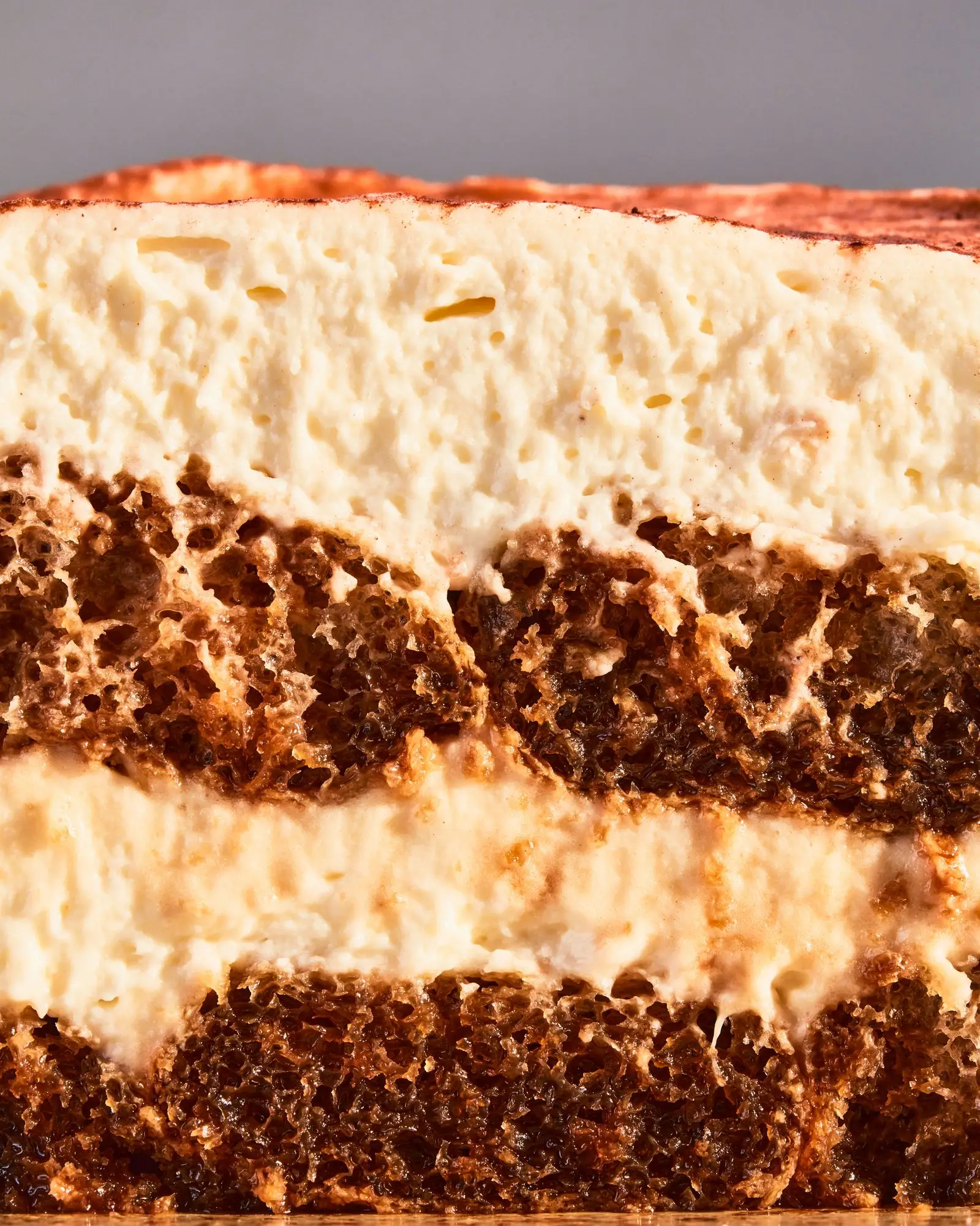 Savoiardi soaked in coffee liqueur and espresso topped with whipped cream and mascarpone and dusted with cocoa powder.