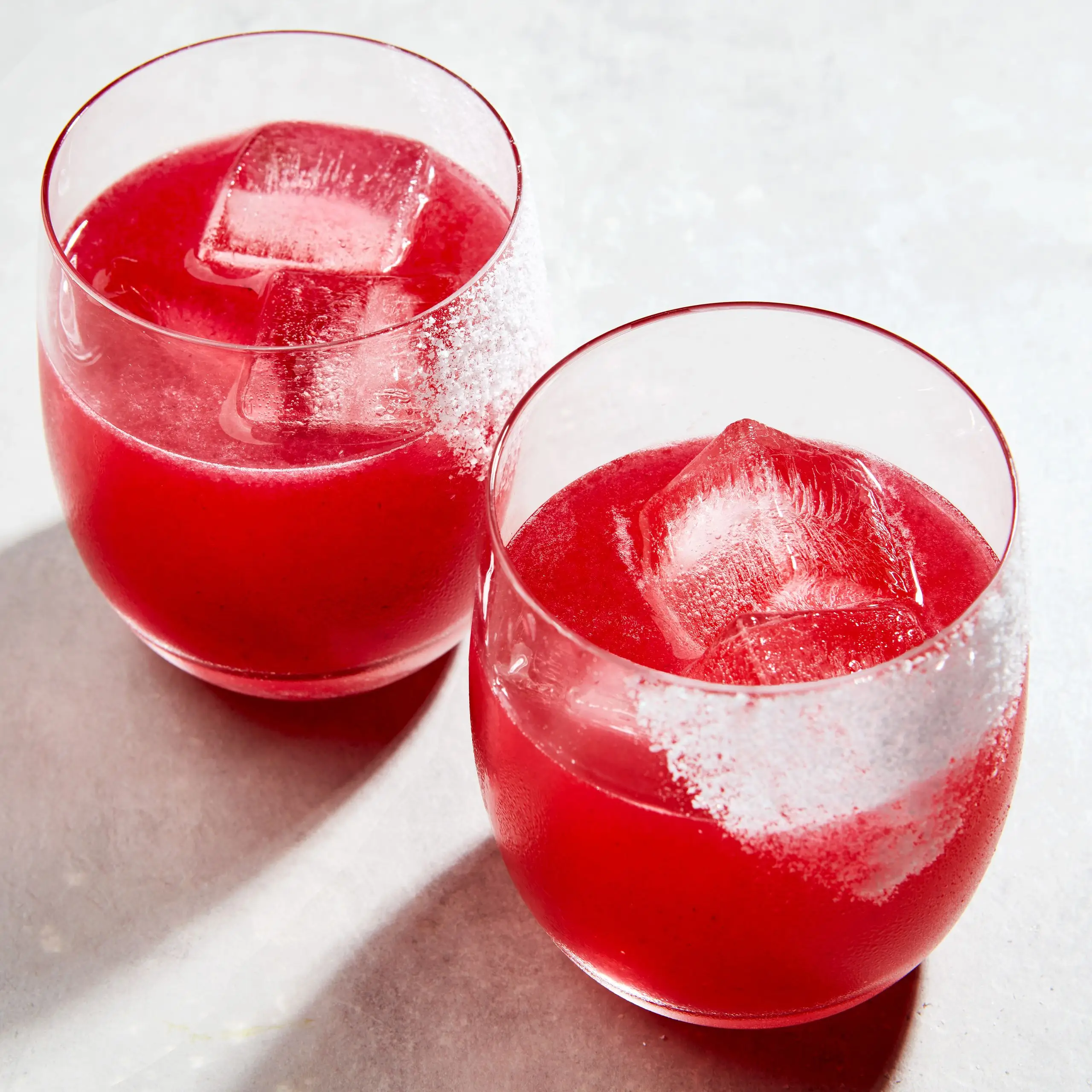 Two blackberry margaritas in salt garnished glasses.