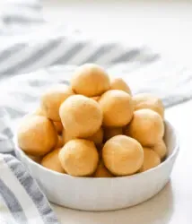 A ramekin filled with old fashioned peanut butter balls (without chocolate) with a striped linen napkin off to the side.' title='No Bake Peanut Butter Balls without Chocolate