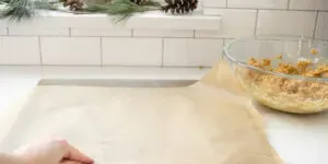 Lining a baking sheet with parchment paper.' title='No Bake Peanut Butter Balls without Chocolate