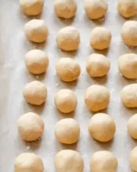 A parchment lined baking sheet with no bake peanut butter balls on it.' title='No Bake Peanut Butter Balls without Chocolate