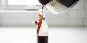 Pouring the chocolate syrup for coffee into a bottle for storage.' title='Chocolate Syrup for Coffee Recipe