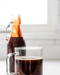 A mug of coffee with chocolate syrup in the background.' title='Chocolate Syrup for Coffee Recipe