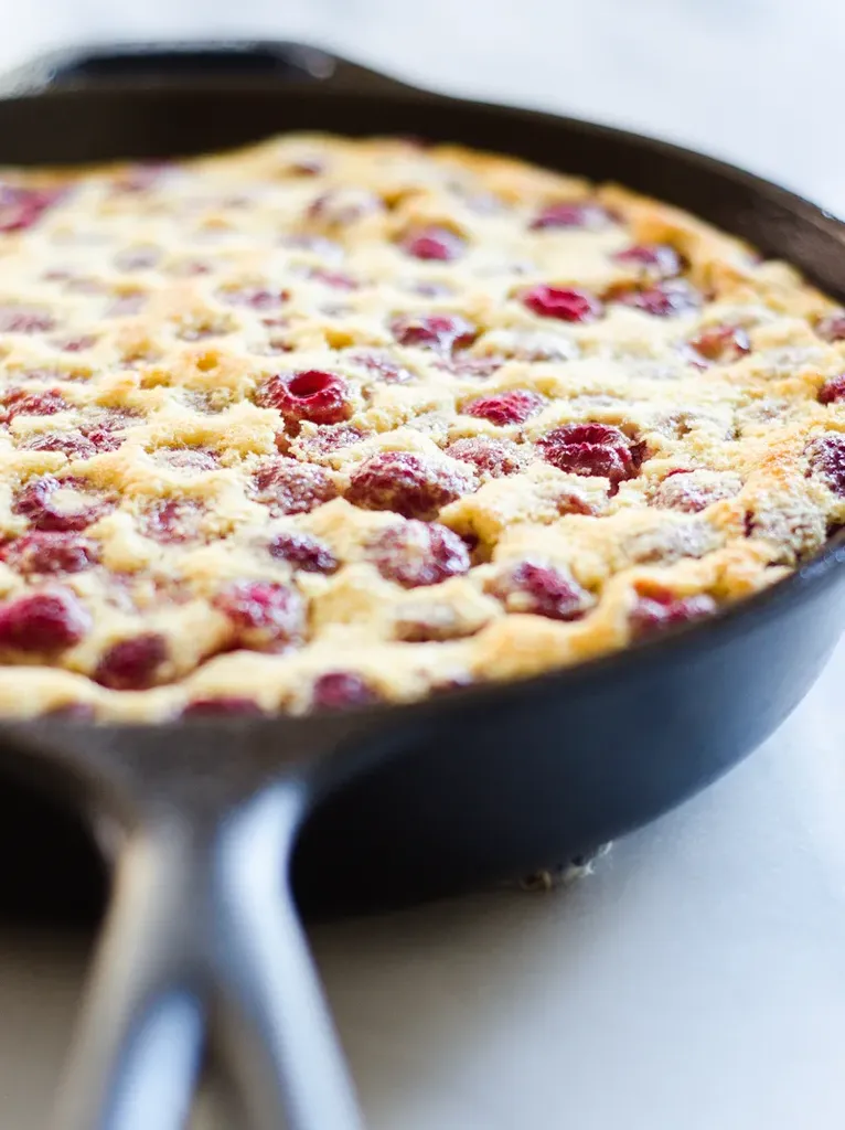 The baked Raspberry Clafoutis in a cast iron skillet.' title='Raspberry Clafoutis