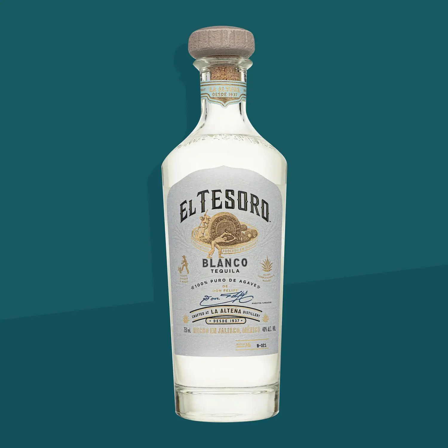 El Tesoro Blanco tequila bottle against a dark teal background.