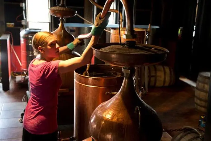 A distillery worker tending to copper pot still at the Montanya rum facility
