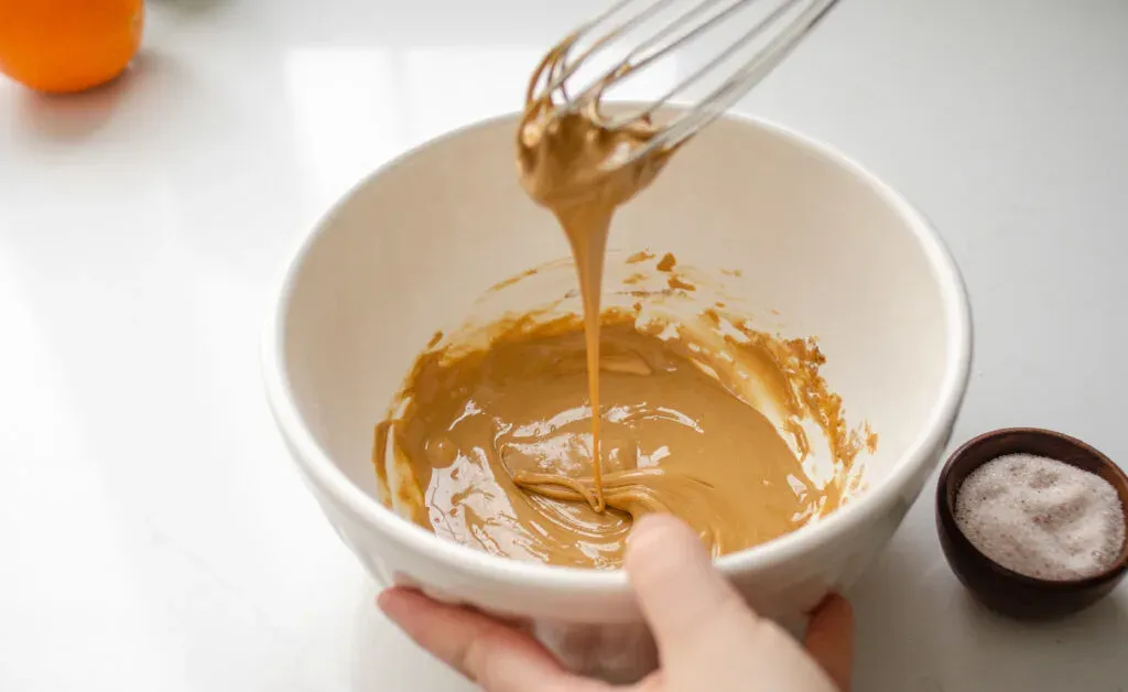 Whisking together the frosting for the cinnamon rolls without milk.' title='Cinnamon Roll Recipe Without Milk